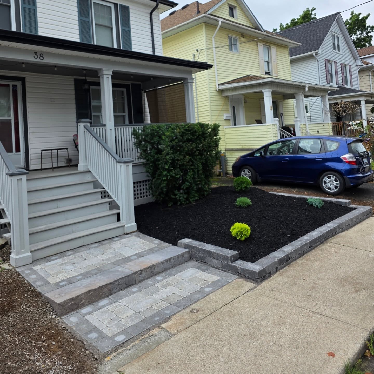 Front yard after: fresh mulch, new plants and an interlock walkway